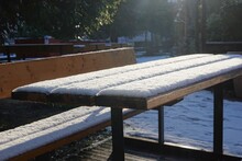 Une Table De Pique-nique En Bois Totalement Recouverte De Neige Et éclairée Par Le Soleil 