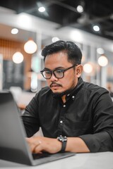 Software developer with a laptop, office background