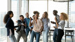© fizkes - Corporate party. Overjoyed group of multicultural students employees dancing in modern office having fun achieving success in teamwork. Excited mixed race colleagues friends celebrate business reward