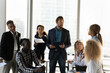 © fizkes - Diversity of opinions. Skilled millennial boss discuss business project with mixed race working group. Black man team leader listen to young woman staff member intern suggesting good idea on briefing