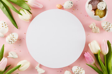 Wall Mural - Crafting a festive Easter setting. Top view shot of egg-shaped saucer, painted eggs, tulips, bunnies, sprinkles on pastel pink background with blank circle for text or promo