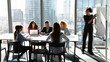 © fizkes - Business education. Diverse group of young mixed race employees gathered in boardroom on training workshop. Corporate team sit at conference table listen to black woman leader presenter speak by board
