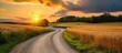 © AkuAku - A sunset road winding through wheat and rye fields.