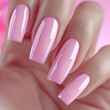 Hand model wearing bright pink nail polish on manicured nails