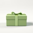 green gift box wrapped with green bow and ribbon, isolated on white background.