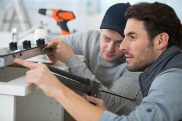 Wall Mural - two men installing a new kitchen hob