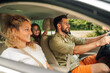 © Zamrznuti tonovi - Happy family of four is driving a car during a weekend trip away from the city
