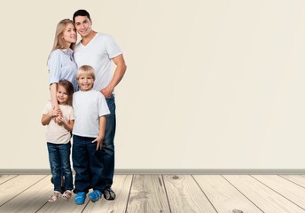 Wall Mural - young joyful parents with children posing on background