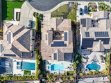 Fototapeta Uliczki - Top Down photo of 3 houses in a affluent neighborhood with solar panels and pools in california