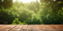 Ideal For Photo Editing Or Showcasing Products, An Empty Wooden Table With A Blurred Green Forest Background And Bokeh Effect.