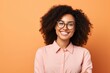 Portrait of smiling african american woman in eyeglasses on orange background