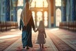 Person in a mosque. A mother wearing a headscarf leads her daughter through the hallway of a mosque