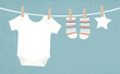Baby boy clothes pinned to a clothesline, in a cut paper style with textures
