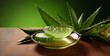 Aloe vera gel in glass bowl with fresh aloe vera leaves on wooden table.