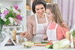 © aletia2011 - Smiling mother and daughter cooking together at kitchen