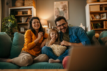 the joy of togetherness as a mom, dad, and daughter share a movie and popcorn in their living room