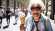 An elderly woman with an ice cream in her hand walks along a city street in summer