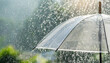 © netsay - Transparent umbrella under rain against water drops splash background. Rainy weather concept.