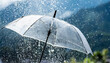 © netsay - Transparent umbrella under rain against water drops splash background. Rainy weather concept.