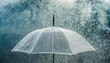 © netsay - Transparent umbrella under rain against water drops splash background. Rainy weather concept.