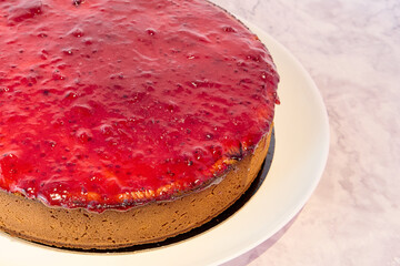 Wall Mural - Close up of a strawberry cheesecake on a white plate with copy space