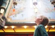 a child looking up in awe at a theaters ornate ceiling