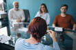 © Jacob Lund - Young female executive talking to her team during a business meeting in a boardroom