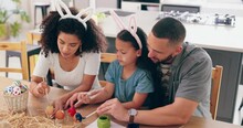 Happy Family, Painting Eggs For Easter In Home, Celebration Together And Color By Paint And Art Creativity. Man, Woman And Daughter For Creative By Paintbrush, Bunny Ears And Festive Holiday In House