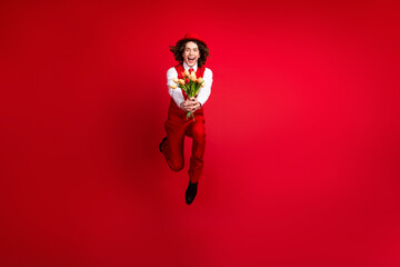 Poster - Full length photo of guy running you in air with fresh flowers tulips to surprise happy valentine day isolated on red color background