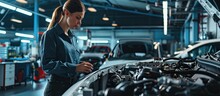 Manager Checks Data On A Tablet And Explains An Engine Breakdown To An Empowering Female Mechanic Car Service Employees Inspect A Car With Internal Combustion Engine Modern Clean Workshop