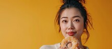 A beautiful asian woman food blogger or vlogger showing a piece of donut while recording a video on camera. Copy space image. Place for adding text
