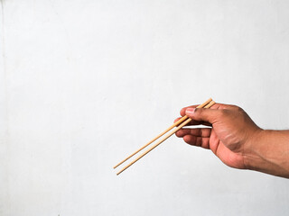 man's hand holding chopsticks isolated white background