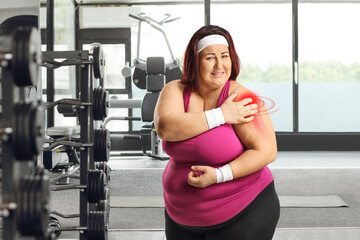 Wall Mural - Woman in a gym suffering from shoulder pain