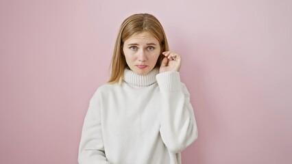 Sticker - Beautiful blonde girl, looking sad and depressed, wearing winter sweater over pink isolated background, exposing anxiety through crying expression, stressed by problems, feeling angry and worried