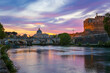 Colorful sunset with view of the Basilica of St. Peter and the Ponte Sant Angelo (Ponte Vittorio Emanuele II) in Rome, Italy