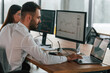 © standret - By the pc monitors. Two employees are working in the office together