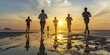 © YuDwi Studio - Group of young people running on beach at sunset. healthy holiday concept