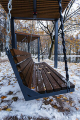 Wall Mural - Wooden swing in the park on a background of the autumn landscape