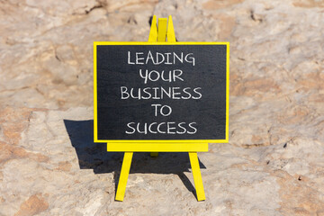 Wall Mural - Leading your business to success symbol. Concept words Leading your business to success on beautiful blackboard. Beautiful stone beach background. Leading your business to success concept. Copy space