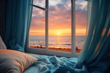  A Bed Sitting Next To A Window With A View Of The Ocean And A Person Walking On The Beach In The Distance.