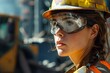 © Kishore Newton - Focused female engineer in hard hat at a construction site, symbolizing women in STEM.