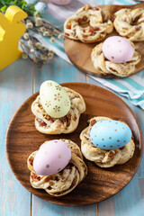 Wall Mural - Sweet italian Easter bread rings from puff pastry and dyed eggs on a wooden blue tabletop.