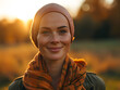 A bald young woman in a headscarf smiles in nature in the sunlight, fighting cancer