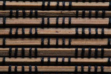 Wall Mural - Brown background made of braided wooden slats.