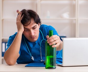 Poster - Young male doctor drinking in the office