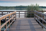 Fototapeta Pomosty - piękny drewniany pomost na jeziorze z zalesionymi brzegami