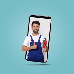 Poster - Plumber looking out of smartphone and showing thumbs up on light blue background