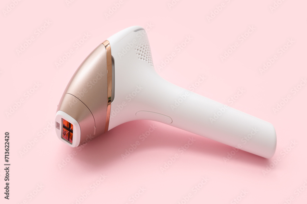 Modern photoepilator on pink background