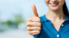A Detailed View Of A Woman's Hand Offering A Thumbs Up, Indicating Approval Or Showing That She Likes Something