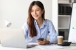 © Kainnika - Asian woman in office is using mobile phone and calling someone, she is smiling with joy and surprise when receiving good news.